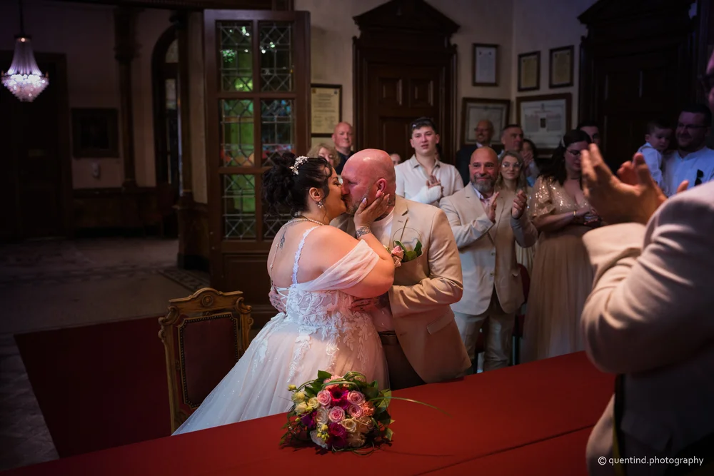 Cérémonie de mariage à la mairie, mariés s'embrassant devant l'officier d'état civil et les invités
