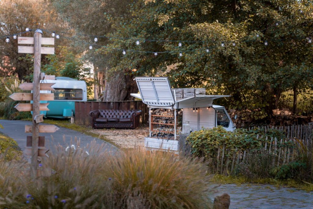 Camion de nourriture vintage avec des chaises et des guirlandes lumineuses dans un cadre de jardin relaxant.
